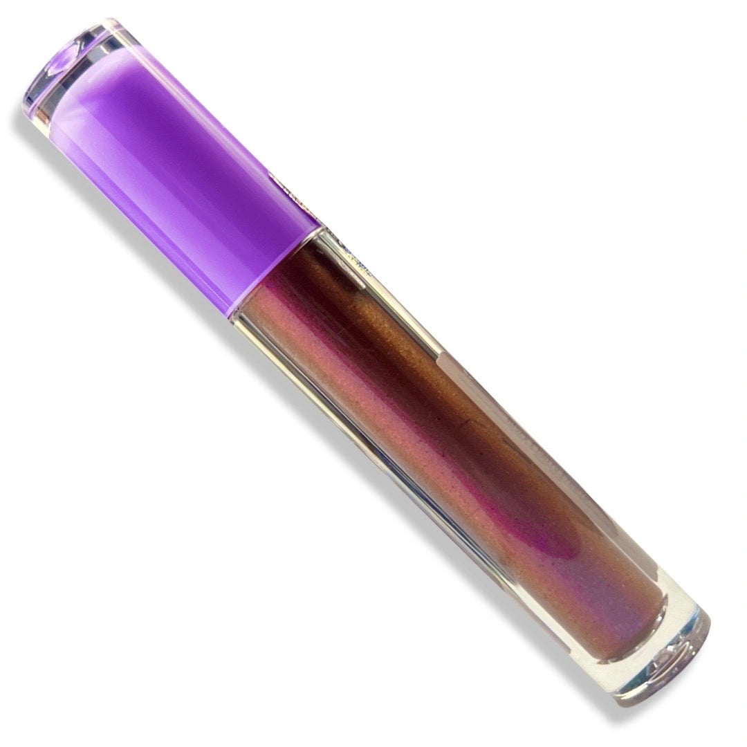 A clear cosmetic tube containing an iridescent red liquid with a metallic purple cap, shown diagonally on a white background.