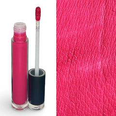 A clear cylindrical tube of bright pink liquid eyeshadow with its cap removed, shown next to a close-up textured swatch of the same vivid pink color on a white background.