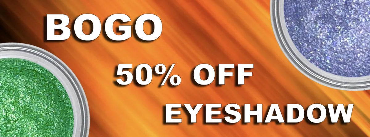 Promotional banner for BOGO 50% OFF eyeshadow, featuring a bright orange gradient background with two round pans of eyeshadow visible at the left and right edges: one green and one blue-purple glittery shade. Large white text reads 'BOGO', '50% OFF', and 'EYESHADOW'.