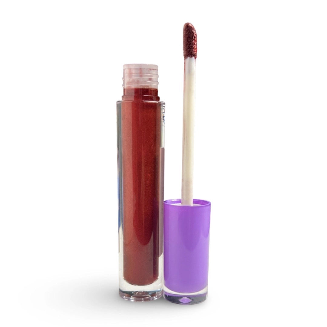 A clear tube of liquid lipstick containing a deep berry red shade, shown next to its bright purple cap and applicator wand on a white background.