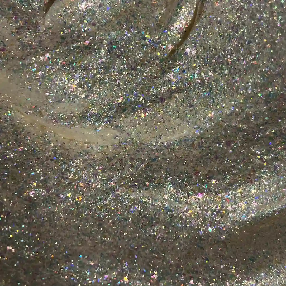 A close-up texture shot of Rainbowlit Elixir with fine reflective flakes and iridescent sparkle.